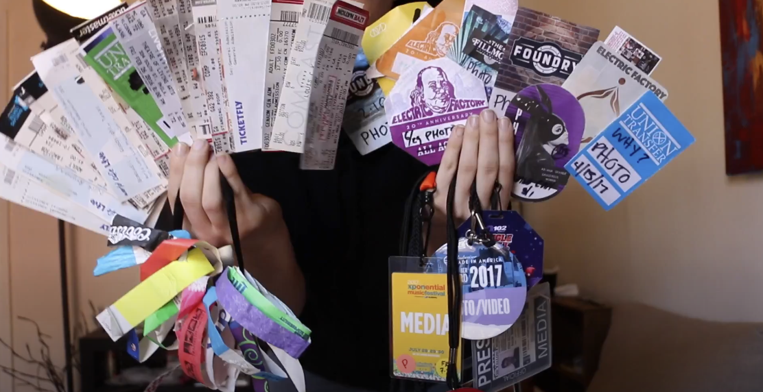 Photo of hands holding a stack of tickets and concert passes