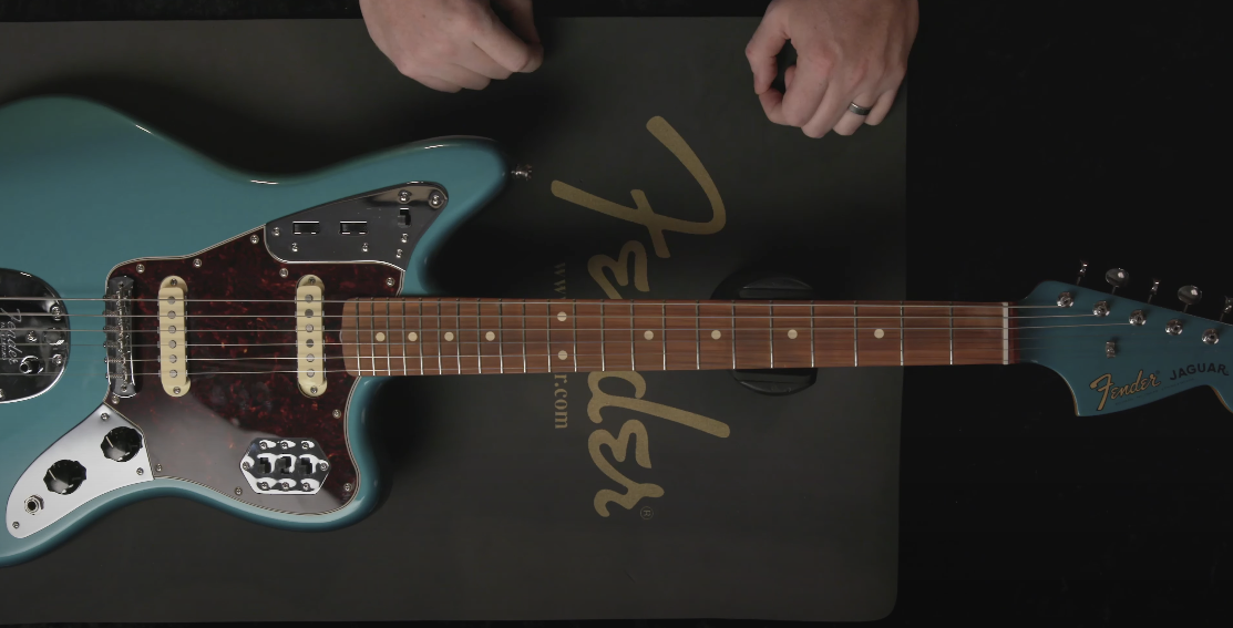 Top view photo of a grayish-blue guitar placed on a table