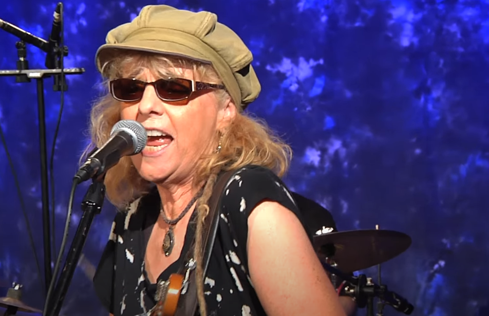 Debbie Davies, a female blues guitarist, takes center stage during a live performance.
