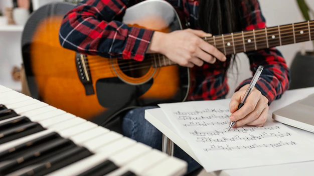 A man sitting with a guitar in his hands learns frets