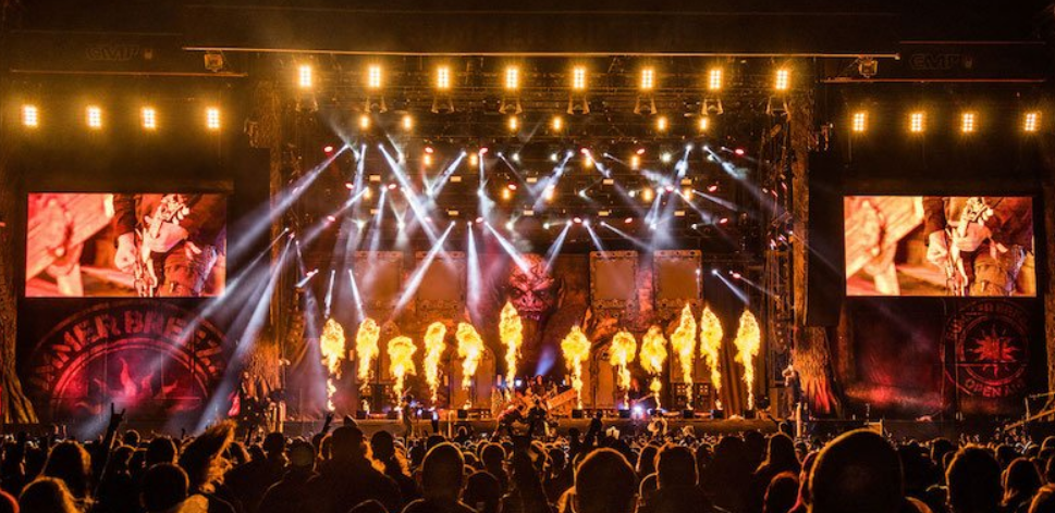 scene of a music festival during a concert, with the audience in the foreground